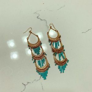 Long gold and turquoise statement earrings.
